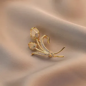 Elegante spilla a tulipano con petali di opale e cristalli su seta color champagne