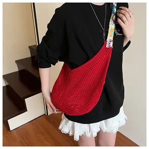Détail d'un sac cabas en crochet rouge avec sangle fleurie et maille bohème tissée main