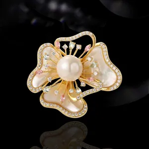 Exquisito broche de flor de nácar con perla blanca y cristales en base dorada