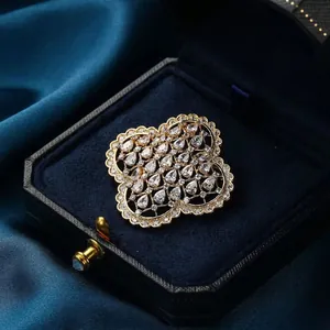 Broche trèfle dorée exquise sertie de zircons cubiques sur un tissu en soie bleue