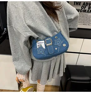 Gros plan sur le sac en jean bleu avec patchs d'étoiles blanches et chaîne argentée