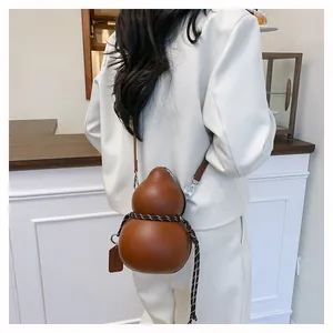 Detail showing the brown gourd-shaped crossbody bag with decorative braided rope detail