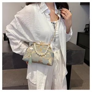 Ethnic embroidery bag with gold floral patterns, pearl handle and flower tassel