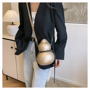 Detailed view of gourd-shaped gold crossbody bag with striped rope and leather strap