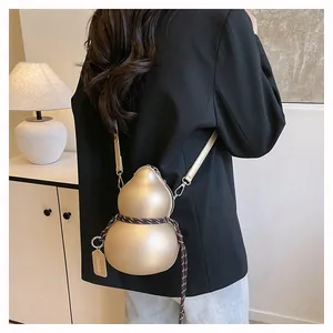 Detail of champagne gold gourd-shaped bag with woven rope and metal brand tag