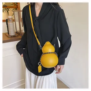 Macro shot of creative yellow gourd-shaped crossbody bag with woven cord and leather strap