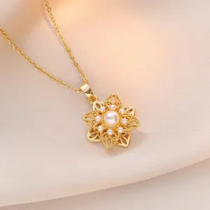 Elegante collar con colgante de flor dorada con perla central y diseño de filigrana