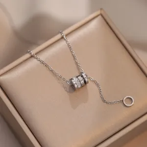 Detail of silver titanium necklace with a sparkling crystal-encrusted cylinder pendant