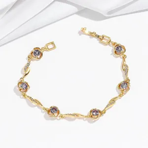 Dettaglio del bracciale a fiori dorato con zirconi viola e cristalli bianchi brillanti