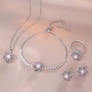Detail von floralem Schmuckset mit lila Edelsteinen und Perlen auf Seidenhintergrund