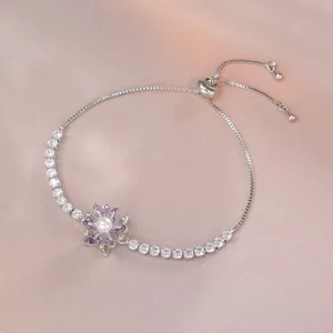 Detail eines verstellbaren Silberarmbands mit lila Blume und weißer Perle im Zentrum