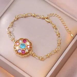 Elegante pulsera dorada con un colgante floral de circonita colorida y cadena ajustable