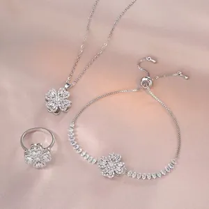 Zilveren sieradenset met klaverketting, armband en ring op roze zijden stof