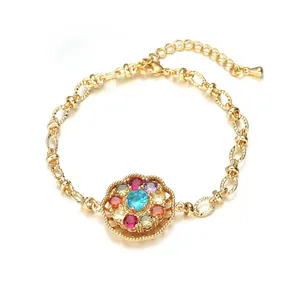 Bracelet doré avec pétales en zircon coloré et gemme bleu ciel sur un fond blanc pur