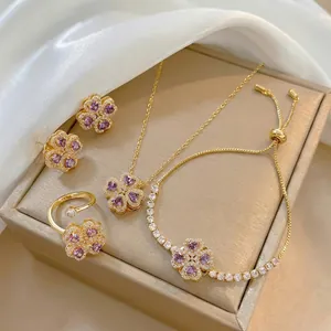 Detail of four-piece clover jewelry set with purple heart stones and gold plating