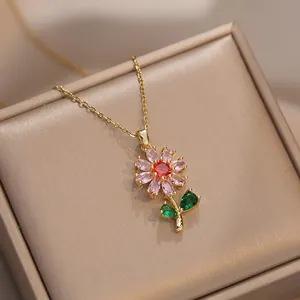 Elegante collar de flor de oro con circonitas de colores en una caja de seda champán