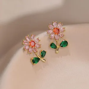 Elegantes pendientes de flor dorada con pétalos rosas y centro naranja en seda