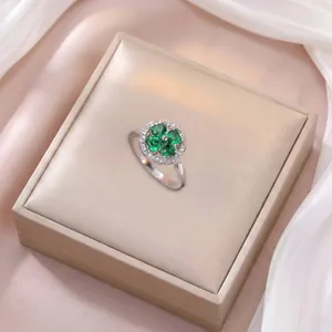 Détail d'une bague en argent ornée de zircons verts émeraude en forme de cœur et trèfle