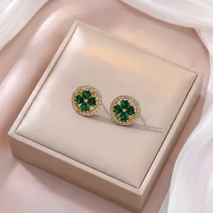 Vue détaillée des boucles d'oreilles trèfle avec pierres en forme de cœur vert émeraude