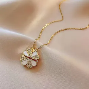 Goldene Herz-Kleeblatt-Halskette mit weißen Muschel-Elementen und kleinen Kristallen