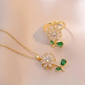 Rotating sunflower jewelry set with zircon necklace and ring on champagne satin fabric