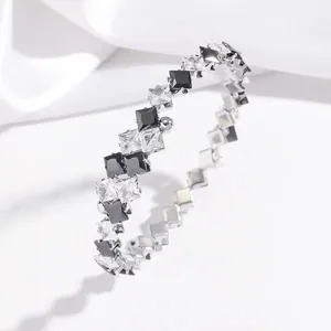 Detailed shot of silver bangle featuring alternating black and white square-cut zircons