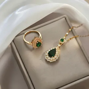 Elegantes Set aus Goldhalskette und Ring mit birnenförmigem Smaragd und Pavé-Kristallen
