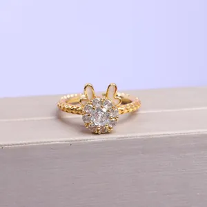 Detalle de un anillo dorado con diseño de conejo y cristales pavé resplandecientes