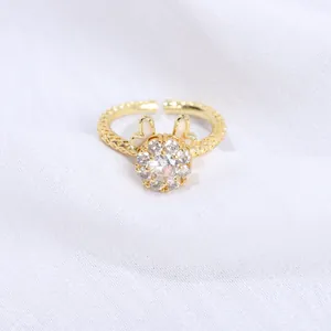 Anillo dorado ajustable elegante con circonitas centrales y detalles de esmalte blanco