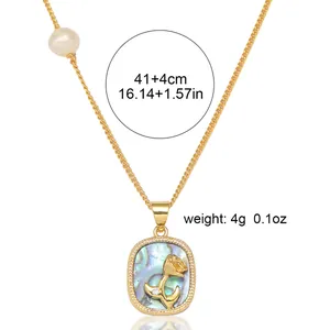 Détail du pendentif queue de baleine doré avec incrustation d'abalone et perle