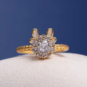 Detalle de un anillo de conejo giratorio chapado en oro con piedras de circonita clara