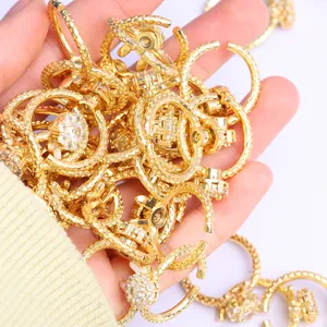 Detalle macro de anillos dorados con textura grabada y piedras de circón brillantes