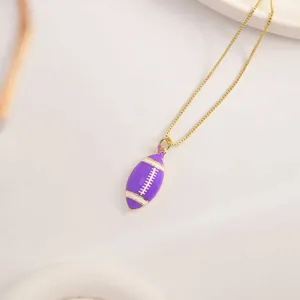 Makroaufnahme von lila Emaille-Rugby-Anhänger mit goldener Box-Kette für Sport-Look