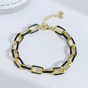 Détail du bracelet chaîne plaqué or 18 carats avec émail noir et fermoir mousqueton