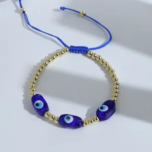 Close-up of blue braided evil eye bracelet with 18K gold beads and adjustable cord