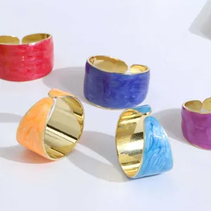 Macro detail of enamel wide band rings with colorful marble texture and gold lining
