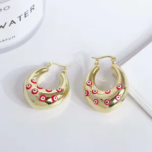 Detailed macro view of 18K gold-plated hoop earrings with colorful evil eye enamel patterns