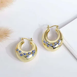 Macro shot of 18K gold-plated thick hoop earrings featuring blue and white Evil Eye patterns