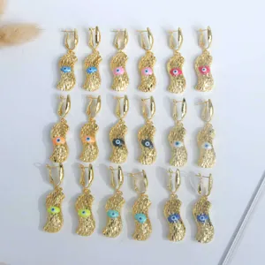 Detalle de pendientes de gota ojo de la suerte bañados en oro de 18K en nueve colores