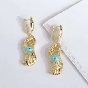 Primer plano de pendientes de gota de cacahuete bañados en oro 18K con ojo turco