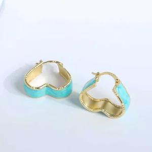 Detail of 18K gold plated heart hoop earrings with light blue enamel and wavy metal texture
