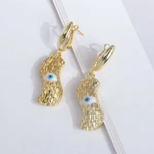 Vista detallada de pendientes de cacahuete chapados en oro de 18K con motivo de ojo y textura