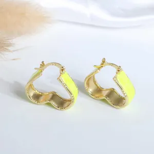 Detail of 18K gold plated hoop earrings with S925 silver mark and bright yellow enamel
