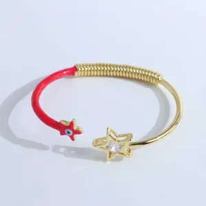 Gros plan du bracelet mauvais œil plaqué or 18 carats avec émail rouge et détail d'étoile