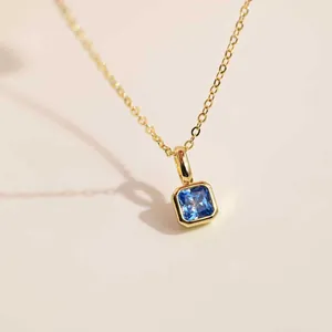 Gros plan détaillé d'un collier avec pendentif zircon bleu carré plaqué or 18 carats
