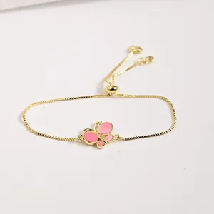 Bracelet ajustable en chaîne dorée avec papillon en émail rose et détails en zircon