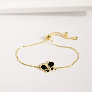 Détails du bracelet papillon doré avec de l'émail noir et des zircons scintillants