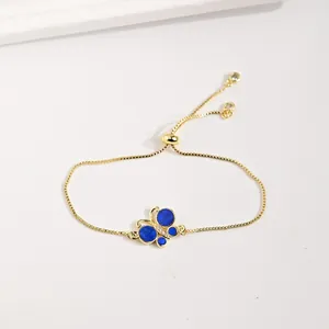 Vue détaillée du pendentif papillon en émail bleu avec zircons et chaîne dorée réglable