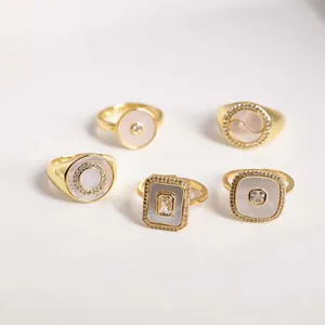 Adjustable golden rings with natural shell inserts and zirconia in geometric heart shapes