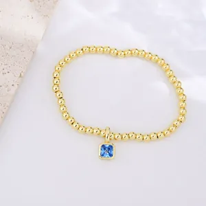 Close-up of 18k gold-plated beaded bracelet featuring a square blue zircon pendant charm